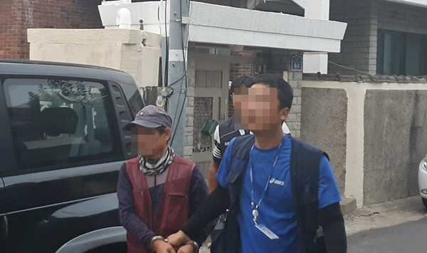 제주해경이 불법체류자 알선책인 중국인 J씨(왼쪽)을 검거해서 연행하고 있다.(사진제공=제주해경)
