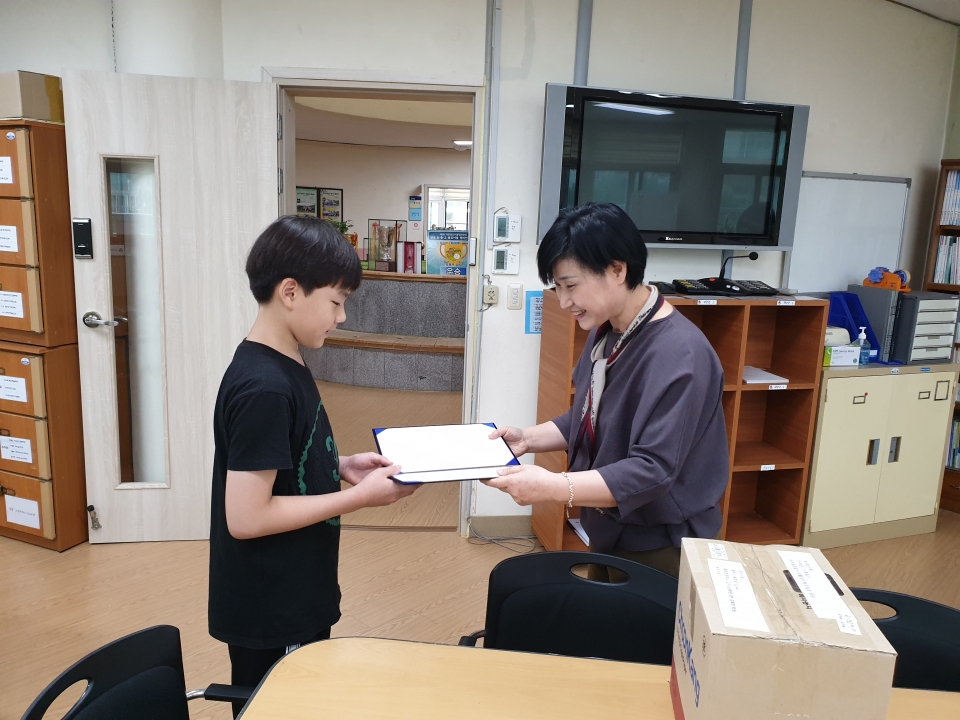 감사장을 받고 있는 김례찬 학생(왼쪽)(사진=동화초등학교 제공)