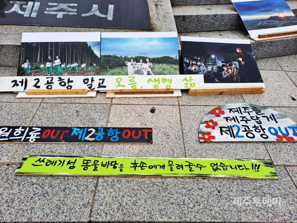 제주 서귀포 가시리 주민 이성홍씨가 거리 시위를 하는 제주시청 조형물 앞에 몇몇 시민들이 제작한 피켓들이 전시돼 있다. (사진=정미숙 작가)