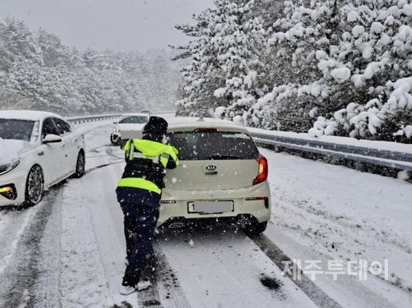 26일 제주경찰이 눈이 쌓인 도로에 미끄러진 차량을 이동 조치하고 있다. (사진=제주특별자치도경찰청 제공)