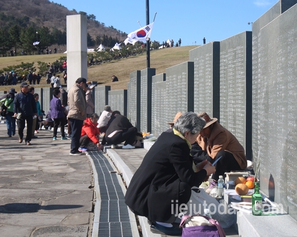4월 3일 제주4.3평화공원에 마련된 묘역에 희생자 유족들이 비석에 적힌 고인의 이름 앞에서 간단히 제를 올리고 있다.@김관모 기자