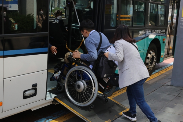 제주장애인자립생활센터 근로자가 장애인 이용자 이지혁씨의 저상버스 탑승을 위해 휠체어를 힘껏 밀고 있다. (사진=박지희 기자)