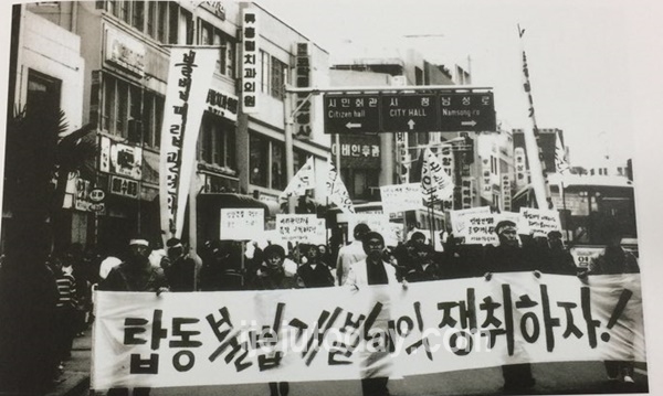 탑동불법매립 개발이익 환수운동1980년대 후반 민주화운동이 전국으로 확산된 이후 제주지역에선 주민운동이 활발히 전개되기 시작했다. 이러한 분위기 속에서 1991년 탑동 매립을 둘러싼 위법성 여부가 언론에 드러나면서 시민사회단체와 대학생들이 적극 참여한 가운데 불법매립에 따른 개발이익환수운동으로 비화됐다. 사진은 남문로 시민회관입구에서 행진에 나서고 있는 시민단체 학생들의 시위장면으로 ‘탑동불법개발이익 쟁취하자’는 플래카드의 구호가 선명하다 (김기삼 사진)@1900~2006 사진으로 보는 제주역사/제주특별자치도 2009