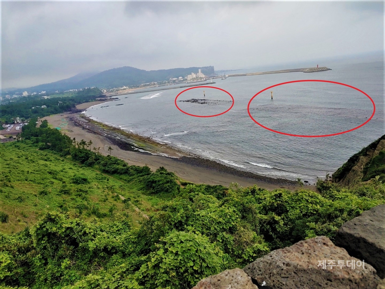 산방연대에서 바라본 풍경. 빨간색 원이 수중방파제이다. 수중방파제 왼쪽으로 지반이 드러난 황우치해변의 모습을 볼 수 있다.(사진=김재훈 기자)