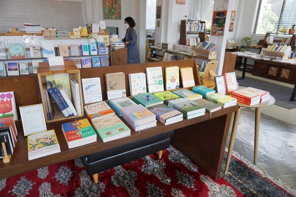 제주시 애월읍 소길리에 위치한 책방 겸 출판사 '섬타임즈'의 신간코너 너머로 이애경 책방지기의 모습이 보인다. (사진=요행)