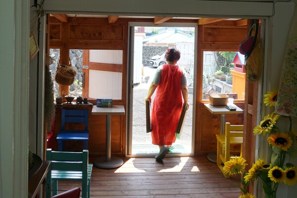 제주시 조천읍에 위치한 동시집 전문책방 '오줌폭탄'. 김정희 책방지기가 책방의 안과 밖을 부지런히 정리하고 있다. (사진=요행)