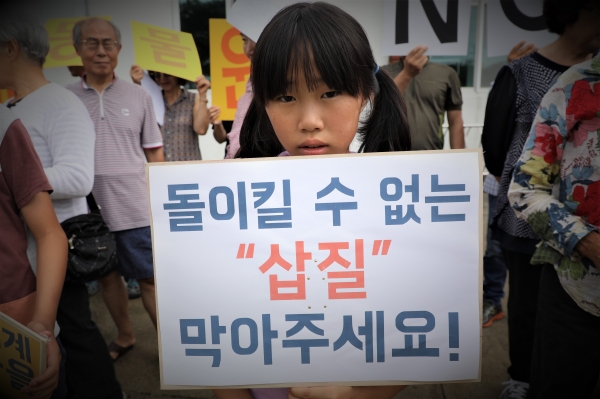 조천읍 선흘리의 한 소녀가 대명 제주동물테마파크를 막아달라는 내용이 담긴 피켓을 들고 있다.(사진=제주투데이 DB)