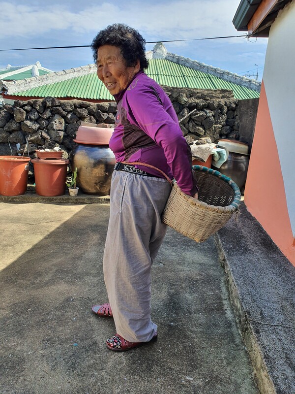 행원리에서 만난 할머니가 촐구덕을 허리에 차고 촐구덕 사용법을 시연해 주고 있습니다. 촐구덕은 보말을 담거나 갯가에 떠밀려온 해초를 담을 때 사용합니다. 촐구덕도 마을마다 이름이 다른가 봅니다. 행원에서는 촐구덕을 ‘웅동 바구니’라 불렀습니다. (사진=고승욱)