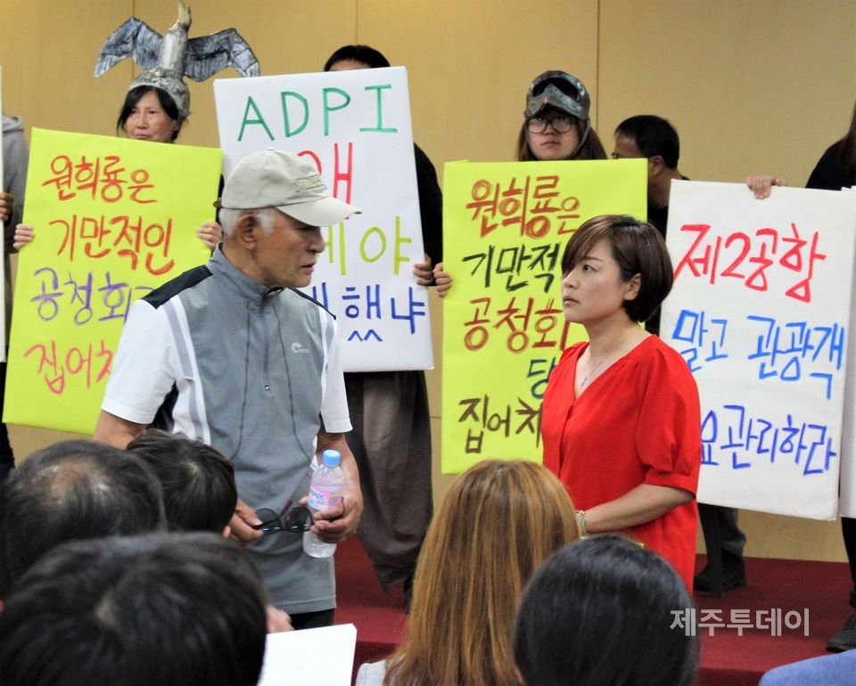 제2공항 관련 공청회에서 제2공항 찬성 측과 얘기나누고 있는 부순정 제주녹색당 공동운영위원장(빨간 옷)(사진=김재훈 기자)