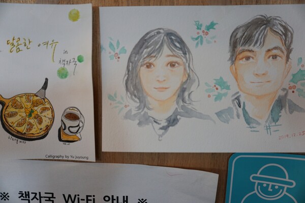 제주시 구좌읍 종달리에 위치한 '카페 책자국' 내 송혜령.고승의 책방지기 그림이 걸려 있다  (사진=요행)