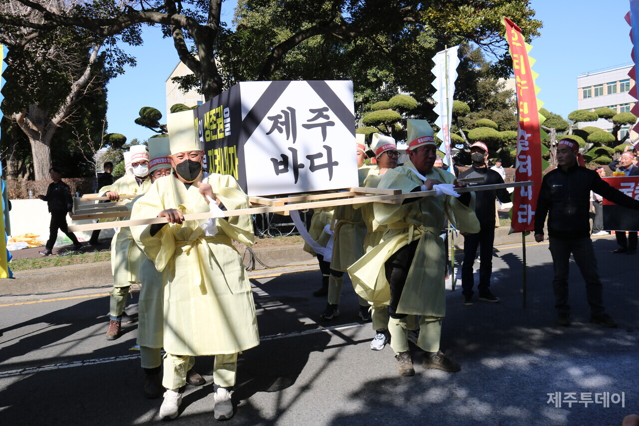 상복을 입은 농어민들이 제주바다로 상징되는 관을 들고 주제주일본국총영사관으로 향하고 있다.  (사진=박소희 기자)
