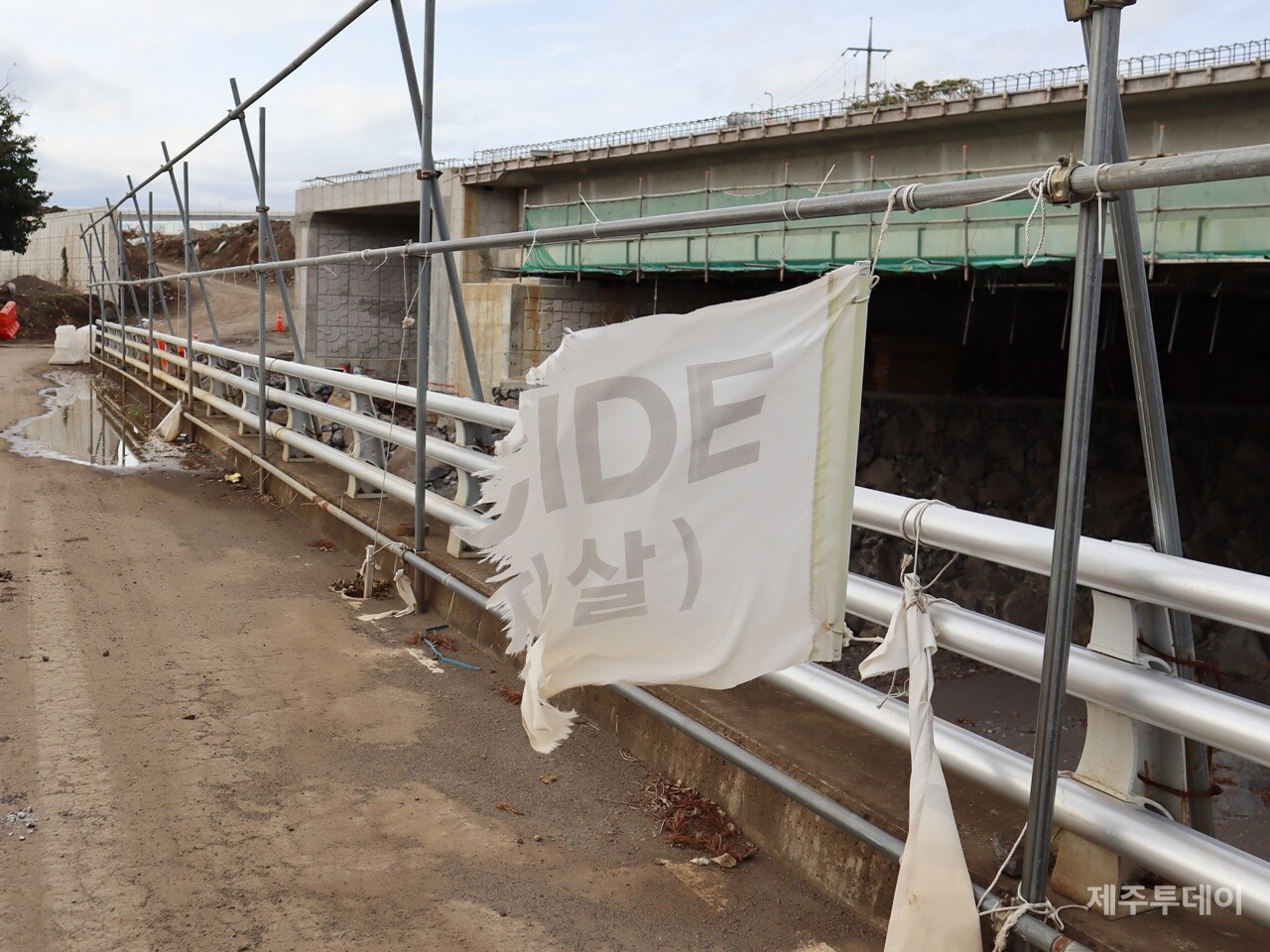 민군복합형 관광미항 진입도로 개설 공사 현장에 매달린 깃발. 원래는 '생태계 파괴는 곧 자살 행위'(Ecocide = Suicide)라는 문구가 적혀 있었다. (사진=박지희 기자)