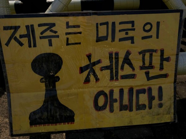 강정마을에 위치한 제주해군기지 정문에 설치된 피켓(사진=강정해군기지반대주민회 제공)