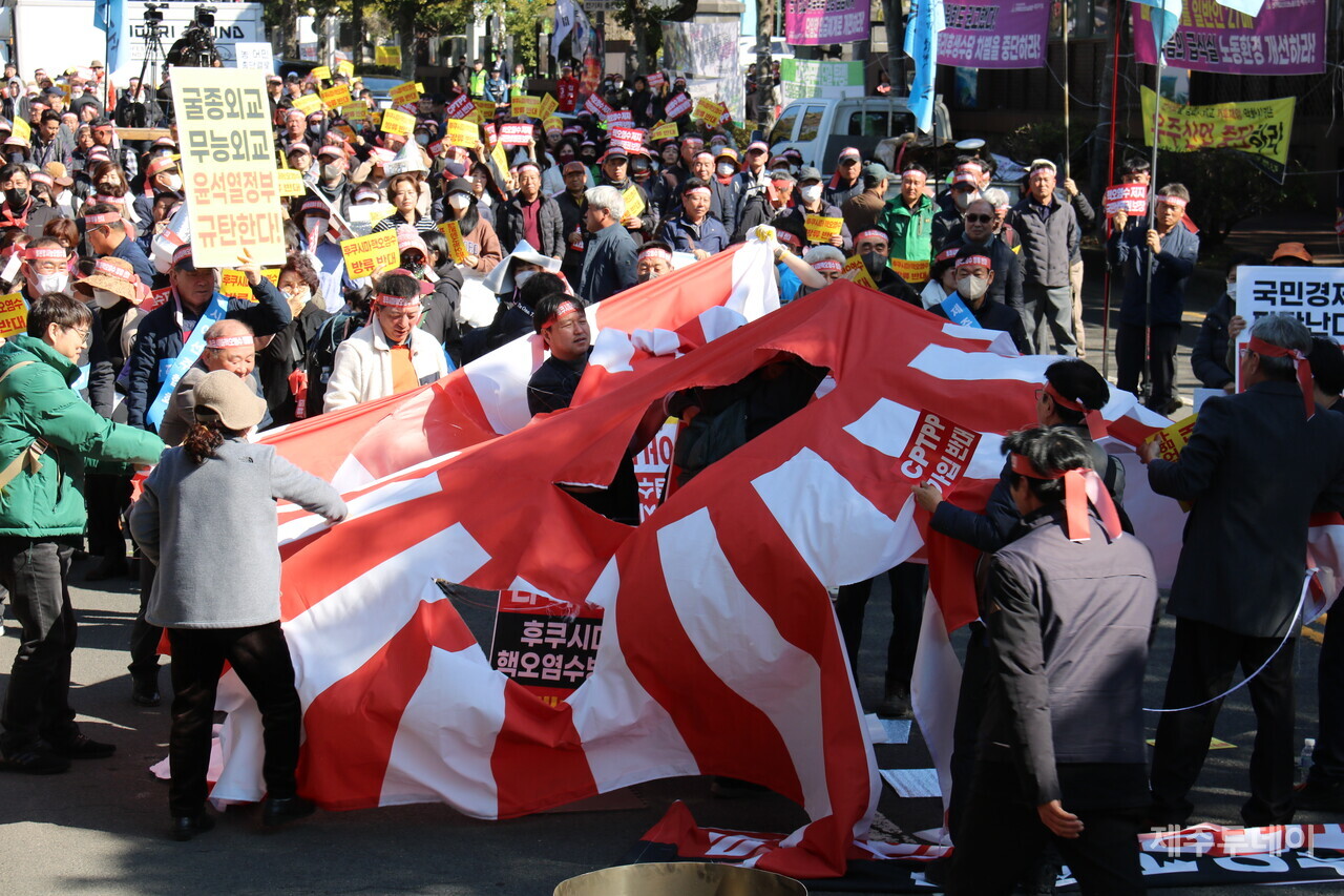 일본 후쿠시마 핵오염수 반대를 위해 모인 이들이 욱일기를 찢고 있다. (사진= 박소희 기자)