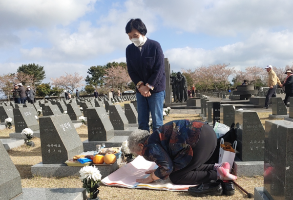 4·3 유족이 행방불명된 희생자의 이름을 새긴 각명비 앞에서 절을 올리고 있다.(사진=김재훈 기자)