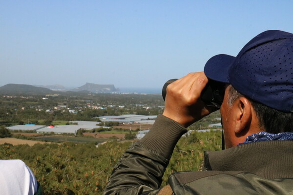 지난 9일 '제주기후평화행진 : 성산편'이 진행된 가운데, 서귀포시 성산읍 신산리 소재 독자봉 정산에서 참여자들이 제주제2공항 후보지 부지를 바라보고 있다. (사진=박지희 기자)