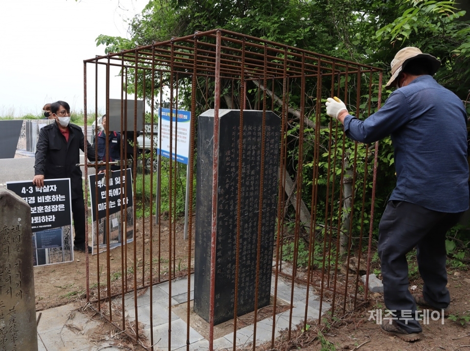 20일 제주특별자치도 보훈청이 ‘4·3 도민 학살 주역’이라 평가 받는 박진경 추도비에 씌운 철창 조형물을 철거하는 과정을 김동현 제주민예총 이사장(왼쪽)이 지켜보고 있다. (사진=조수진 기자)
