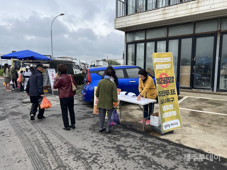 정의당 제주도당 민생현안대응위원회가 지난 15일 제주시 구좌읍 세화민속오일시장에서 제2공항 건설 관련 주민투표 실시촉구 서명을 진행하고 있다. (사진=정의당 제주도당 제공)