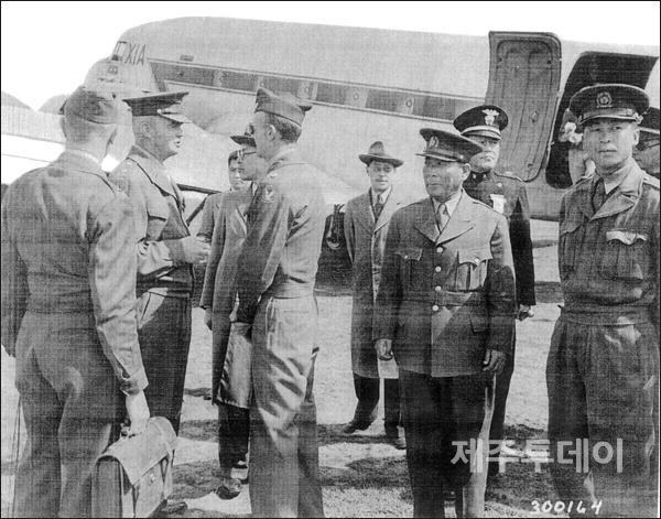 1948년 5월5일 제주비행장에 도착한 미군정 수뇌부, 왼쪽 두 번째부터 군정장관 딘 소장, 통역관, 안재홍 민정장관, 맨스필드 제주군정장관, 유해진 제주도지사, 송호성 총사령관, 조병옥 경무부장, 김익렬 9연대장, 최천 제주경찰감찰청장. 4.3진상조사보고서에는 딘 소장과 악수하고 있는 인물이 유해진 지사로 기록돼 있으나, 이후 확인 결과 안재홍 민정장관인 것으로 확인됐다. (사진=미국립문서기록관리청 소장 자료)