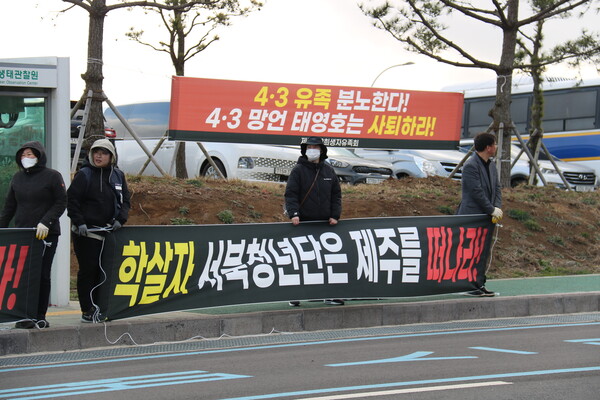 올해 4월 3일 오전 제주4.3평화공원에서 75주년 4.3희생자추념식이 거행되기 전, 시민사회단체가 이날 집회를 예고한 자칭 '서북청년단 구국결사대'의 퇴거를 요구하는 현수막을 들고 있다. (사진=박지희 기자)