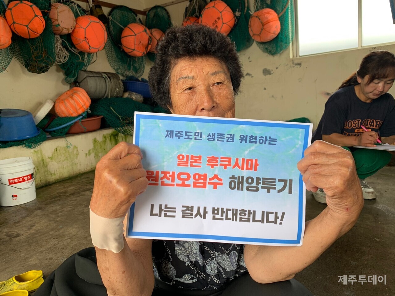 핵오염수 해양투기 반대 피켓을 들고 있는 제주 해녀 (사진=강순아)