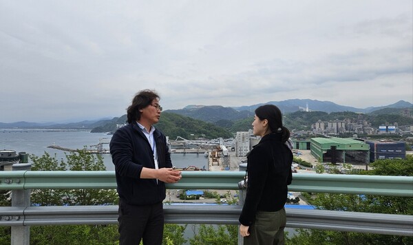 삼척항을 내려다 보며 삼척시 도시재생 사업에 대해 설명 중인 심윤보 삼척시도시재생지원센터 사무국장(왼쪽). (사진=김재훈 기자)