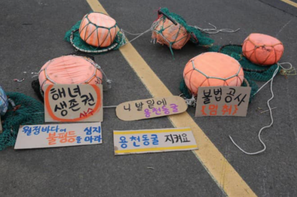 재난피해를 전가하는 하수종말처리장 증설을 반대하는 월정리 해녀들이 그들의 태왁을 바당이 아닌 길바닥에 놓았다. 용천동굴이란 말이 자주 등장하는 것은 현재의 월정리 제주동부하수처리장이 용천동굴 보호지역과 겹치기 떄문이다. 용천동굴 하류 호수구간 일부는 세계자연유산 보고에 누락되었다. 월정리 해녀들은 자신들의 투쟁을 “미래를 위한 싸움‘이라고 했다. (사진, 글=엄문희)