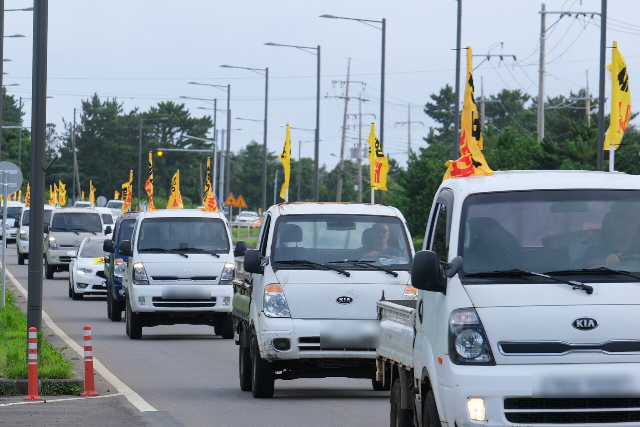 24일 전국농민회총연맹 제주도연맹이 '제주 제2공항 저지 농민전진대회'를 개최한 가운데, 농민들이 이날 오후 5시 30분 제2공항 건설사업 예정 부지인 서귀포시 성산읍 일대 도로에서 '제2공항 반대 현수막이 달린 트랙터.트럭 등을 몰며 차량시위를 하고 있다.  (사진=박지희 기자)