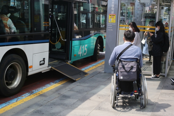 휠체어 이용 장애 당사자가 제주시 일도2동 소재 버스정류장에서 저상버스를 탑승하려고 대기하고 있다. (사진=박지희 기자)
