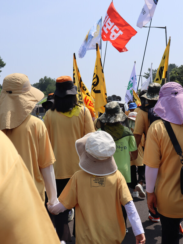 제주생명평화대행진 이틀차인 22일  광주에서 온 가족생활공동체 '애자람그룹홈' 구성원들도 발걸음을 함께 한 가운데, 8세 막내가 누나의 손을 잡고 걷고 있다. (사진=박지희 기자)