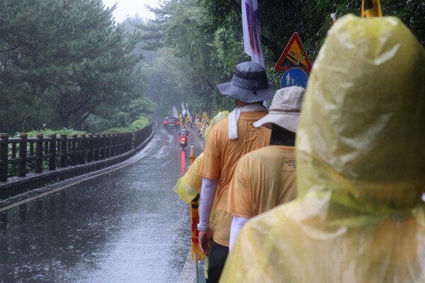 22일 서귀포시 강정동 제주해군기지에서 제주시청까지 걷는 '2024 제주생명평화대행진'이 진행된 가운데, 100여명의 참가자들이 해군기지 정문에서 남원읍까지 호우 속에서 행진하고 있다. (사진=박지희 기자)