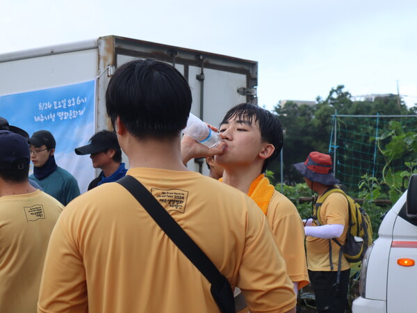 22일 서귀포시 강정동 제주해군기지에서 제주시청까지 걷는 '2024 제주생명평화대행진'이 진행된 가운데, 100여명의 참가자들이 해군기지 정문에서 남원읍까지 행진하다 쉼터에서 쉬고 있다. (사진=박지희 기자)