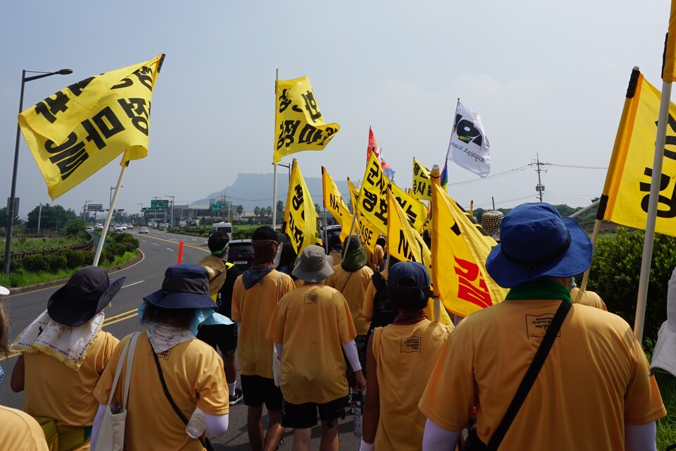 24일 '2024 제주생명평화대행진' 마지막날,  참여자들이 제주제2공항 예정지인 서귀포시 성산읍 성산일출봉 일대를 행진하고 있다.  (사진=양유리 기자)
