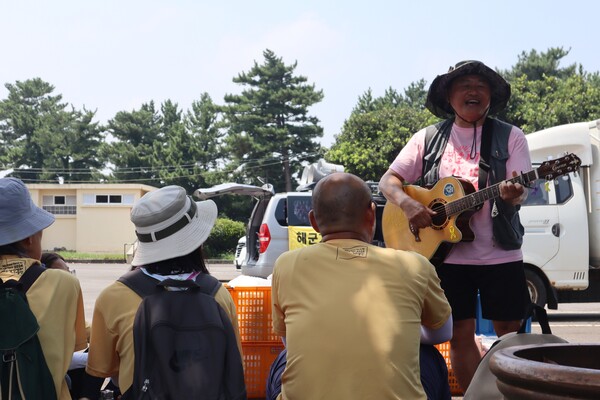 24일 '2024 제주생명평화대행진' 마지막날,  참여자들이 점심식사 후 노래를 부르며 쉬고 있다. (사진=박지희 기자)