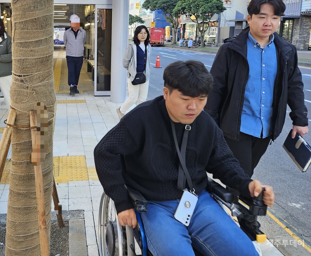 섬식정류장 보행로 중앙에 설치된 나무를 피해 이동 중인 이지혁 대리(사진=김재훈 기자)