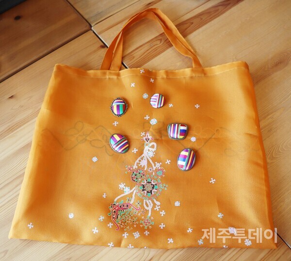 제주리본협동조합 조합원들이 한복 원단을 활용해 만든 쇼퍼백과 색동 브로치. (사진=조수진 기자)