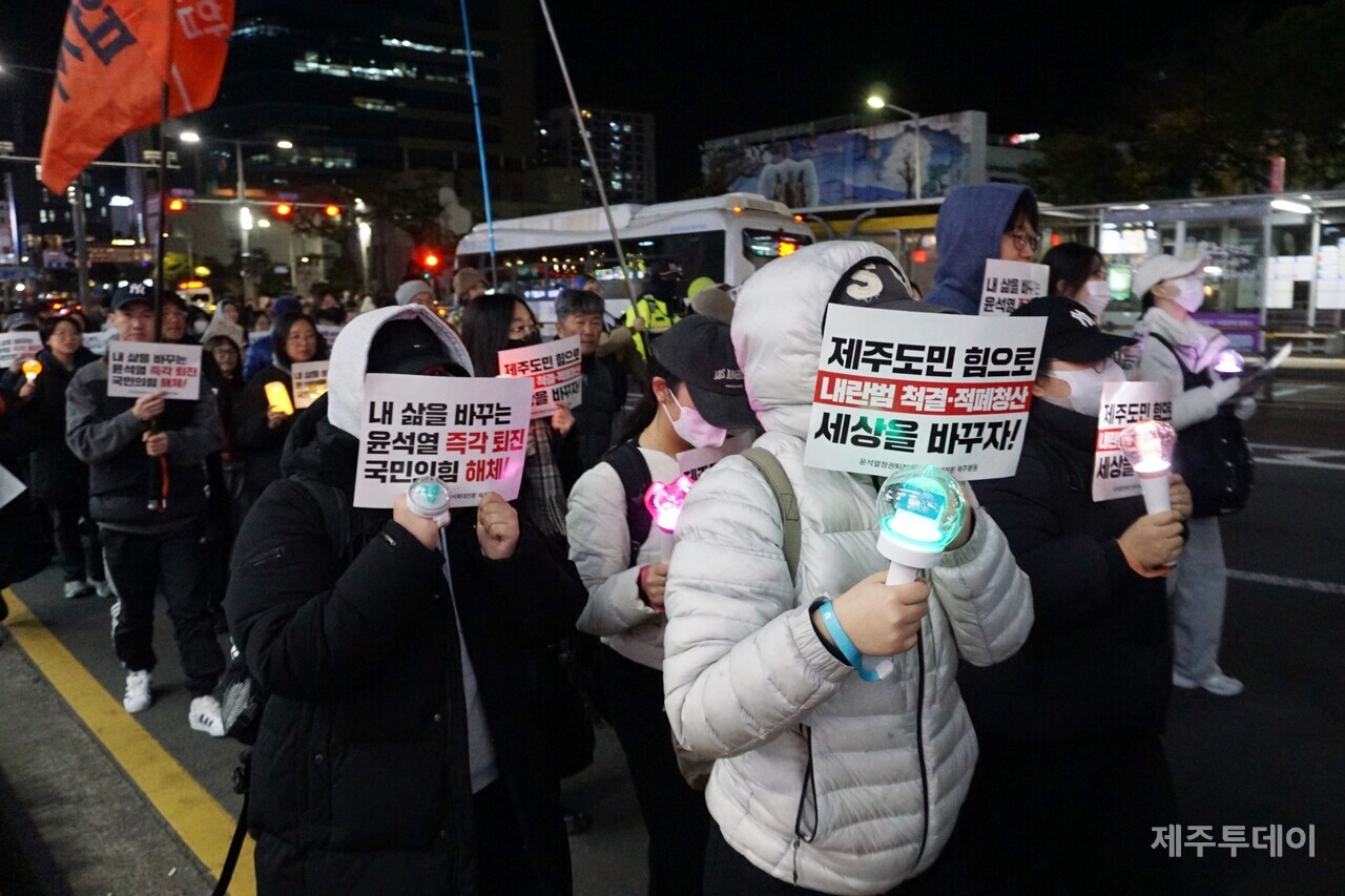 10일 열린 윤석열 즉각 퇴진 요구 제주도민대회에서 참가자들이 피켓과 응원봉을 들고 있다. (사진=양유리 기자)