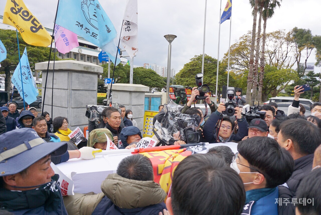 전국농민회총연맹 제주도연맹이 13일 국민의힘 장례식을 위해 제주도의회 안으로 진입하는 과정에서 청원경찰, 도의회 직원들이 막아서면서 소동이 빚어졌다. (사진=양유리 기자)