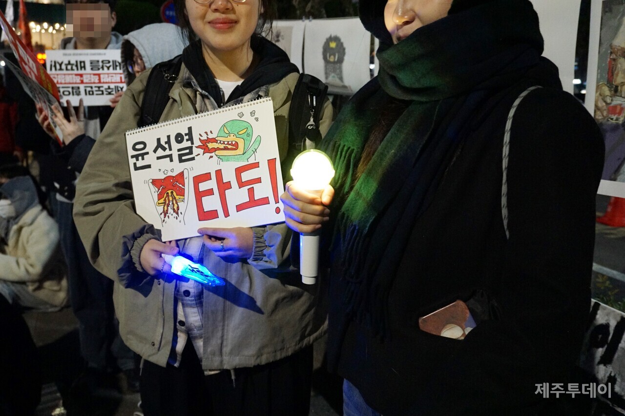 10일 열린 윤석열 즉각 퇴진 요구 제주도민대회에서 참가자들이 피켓과 응원봉을 들고 있다. (사진=양유리 기자)