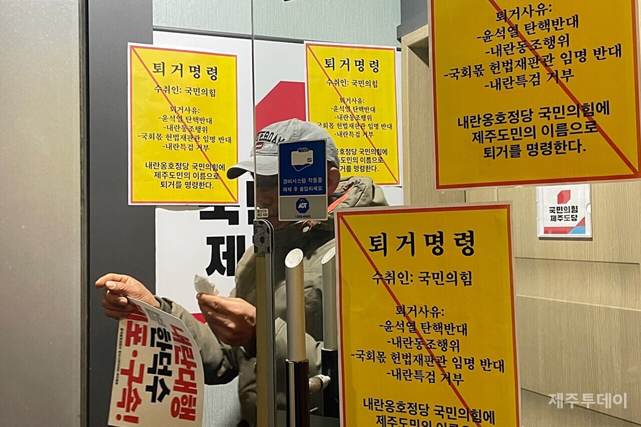 윤석열정권퇴진·한국사회대전환 제주행동이 27일 오전 국민의힘 제주도당 내부에 '퇴거명령' 문서를 부착하고 있다. (사진=양유리 기자)