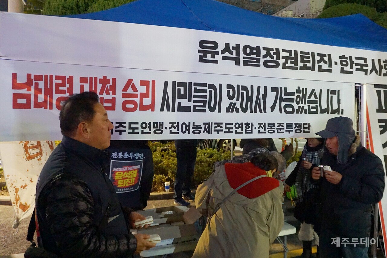 28일 열린 ‘윤석열 즉각 파면·처벌! 내란세력 청산! 사회대개혁! 제주도민대회’에서 전봉준투쟁단 제주투쟁단이 시민들에게 떡과 보리차를 나눠주는 모습. (사진=양유리 기자)