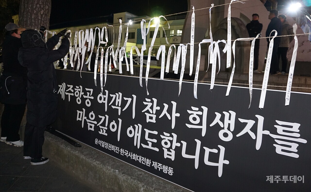 4일 오후 7시 제주시청 민원실 앞에서 열린 ‘윤석열 즉각 파면·처벌! 내란세력 청산! 사회대개혁! 제주도민대회’에서 참가자들이 제주항공 여객기 참사 희생자들에게 애도의 메세지를 담은 끈을 매듭 짓고 있다. (사진=양유리 기자)