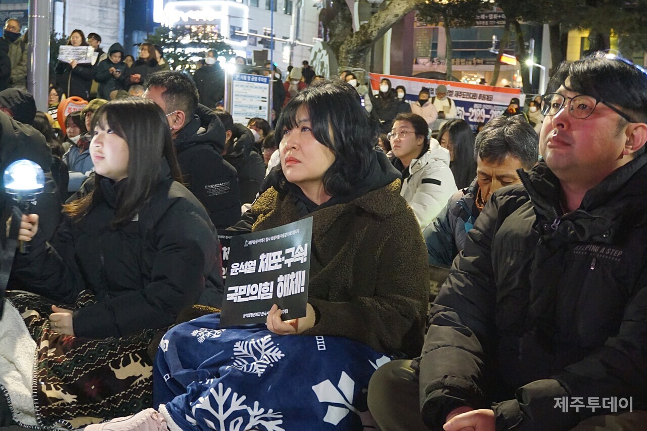 윤석열정권퇴진·한국사회대전환 제주행동은 4일 오후 7시 제주시청 민원실 앞에서 ‘윤석열 즉각 파면·처벌! 내란세력 청산! 사회대개혁! 제주도민대회’를 열었다. 참가자들이 든 응원봉에는 검정색 리본이 달려 있다. (사진=양유리 기자)