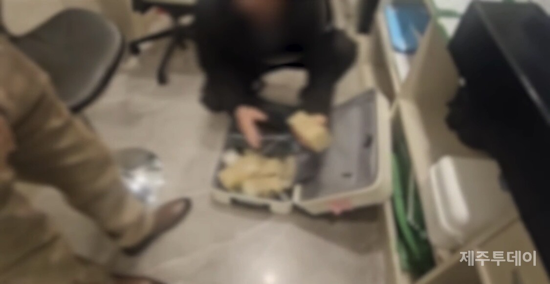 경찰이 지난 19일 A씨 일당이 다른 호텔에 숨겨놓은 현금 1억460만 원을 압수하고 있다. (사진=제주서부경찰서 제공)