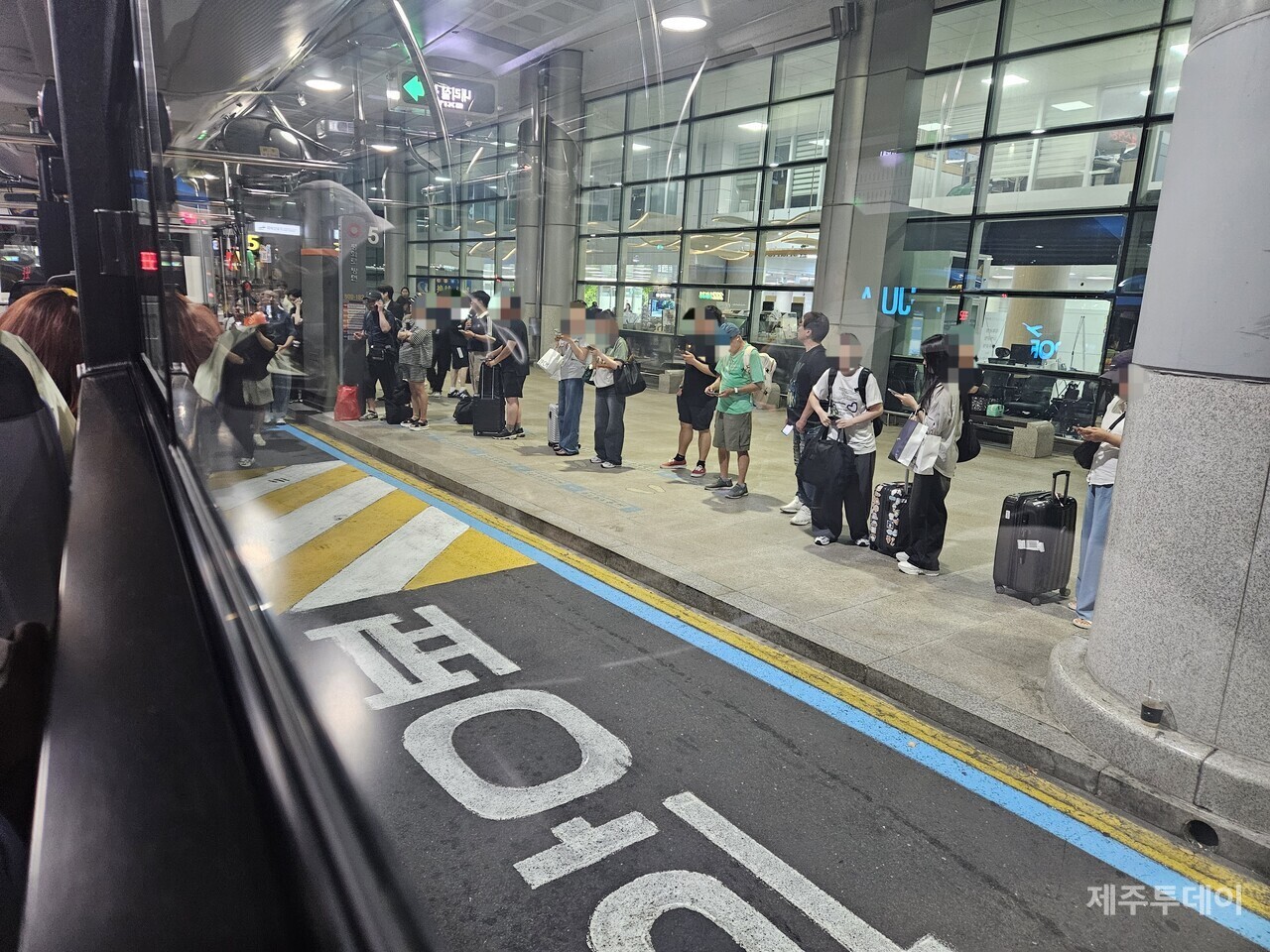 제주공항 내 교통혼잡으로 인해 승차장 가까이 정차하지 못한 버스에 탑승하기 위해 버스 이용자들이 차도로 내려서고 있다.(사진=김재훈 기자)